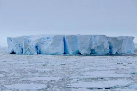 Large blue iceberg at edge of pack ice in antarctic ocean, Antarctica Stock Photos
