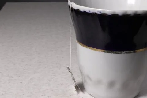 A large blue mug close-up with a hanging thread from a tea bag. Stock Photos