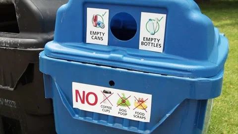 Large blue recycle bin with circle opening and white sticker captions in black Stock Footage 246610616