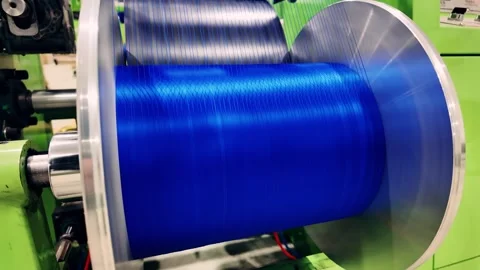 A large blue thread wound on an industrial spool, used in advanced textile Vidéo 323611233