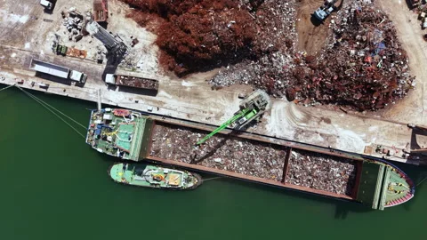 Large boats loading and unloading scrap materials at a recycling yard located Video stock 337914613