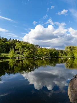 A large body of water surrounded by trees and rocks Stock Photos
