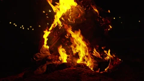 Large Bonfire Blazing at Night, Warm Flames Against Dark Background Stockbeeldmateriaal 336446028