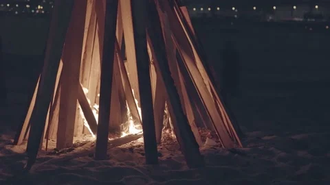 A large bonfire surrounded by firewood, inside fire and coals, coal falls inside Stock Footage 220321061