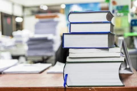 Large books stacked on a table in a library. Stock Photos