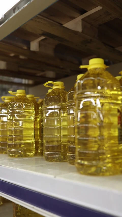 Large bottles of golden vegetable cooking oil displayed on retail shelves Stock Footage 345977880