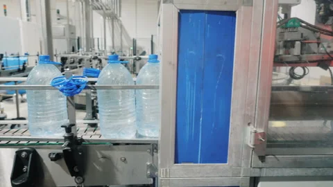 Large bottles with water move through control arch in shop Video stock 163332730