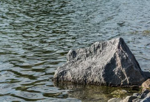 Large boulder at lakeside Stock Photos