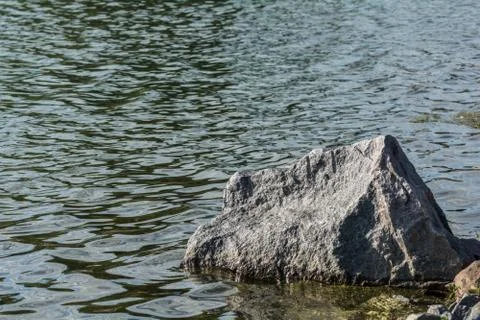 Large boulder at lakeside Stock Photos