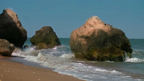 Large boulders, rocks, washed by the surf waves under the bright sun at noon Stock Footage 220632826