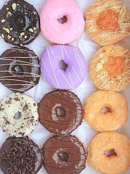 A large box of colorful assorted delectable doughnuts Photos