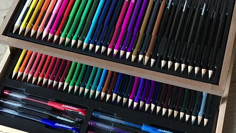 A large box of multi coloured pencils and marker pens is opened. Stock Footage 140962010