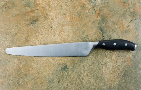 Large bread knife on natural stone Stock Photos