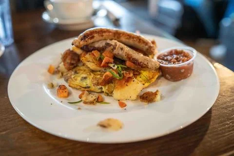 Large breakfast platter including eggs, sausage, potatoes, veggies, and sal.. Stock Photos