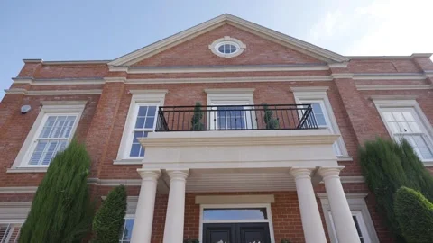A large brick building with a balcony and a white trim Stock Footage 297870272