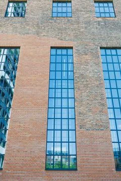 Large brick building with big windows and clear reflections in a modern urb.. Stock Photos