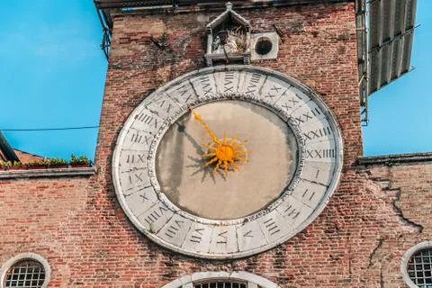 A large brick tower with a clock on the side of a building Stock Photos
