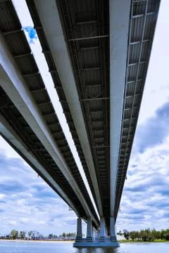 Large bridge over the river, view from below. On the background of contrastin Stock Photos