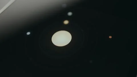 A large bright central disk with smaller dots orbiting, graphic presentation for Stock Footage 332063106