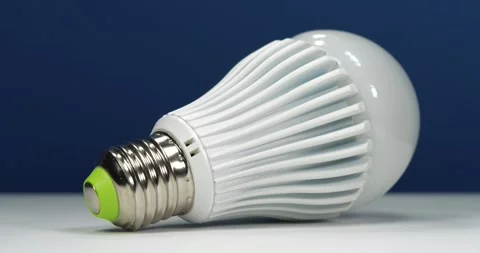 Large bright LED lamp with E27 base on dark blue background Stock Footage 332308963