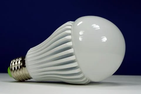 Large bright LED lamp with E27 base isolated on dark background Stock Photos