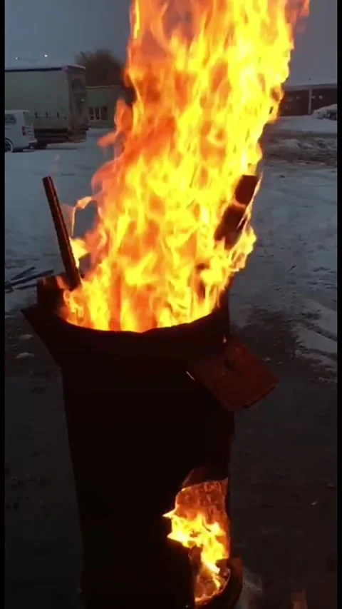 Large bright orange flames burning intensely inside a black metal barrel 動画素材 333241032