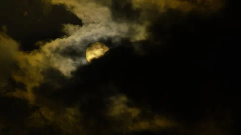 A large, bright sun peeks through a thick layer of dark clouds Vídeo Stock 306028487