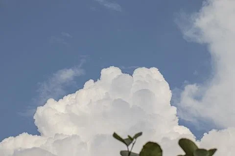 Large bright white clouds climbing in the blue sky during summer days Stock Photos