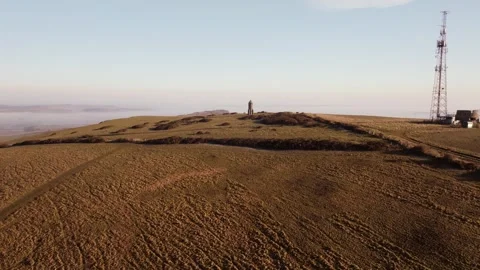 A large, brown field with a tower in the distance Stock Footage 303987329