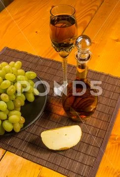 Large brush of green grapes in a ceramic plate, a decanter and a glass of win Stock Photos