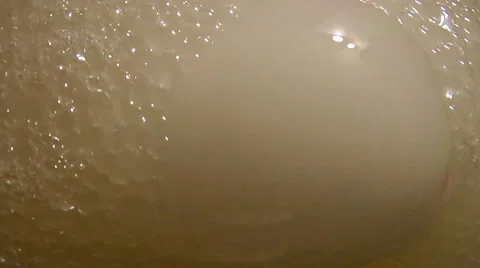 Large bubbles filled with white smoke pop and release more smoke from below Stock Footage 46940081