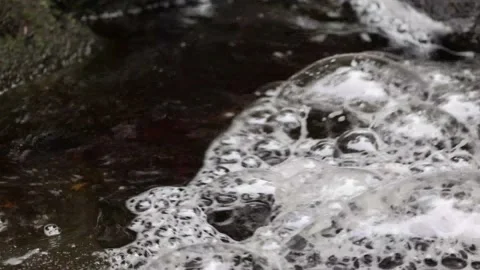 Large bubbles flowing down river Stock Footage 140518525