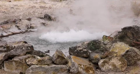 A large bubbling volcanic hot spring pond splashing water and steam at Furn.. Stock Footage 335026387