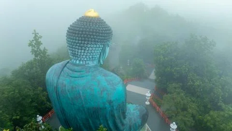 Large Buddha Statue Overlooking Misty Forest Landscape In Lampang Province .. Photos