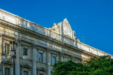 A large building with a clock on the front in Milano city Italy Stock Photos