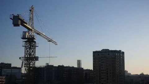 Large building crane in the city on the background of houses and sky in the rays Stock Footage 74369340