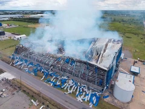 A large building is on fire and the smoke is billowing into the sky Stock Photos