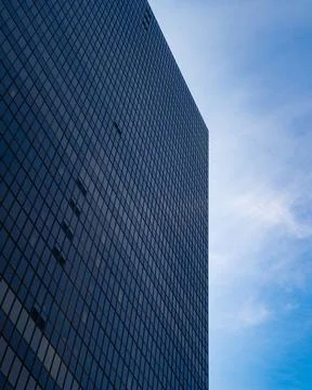 Large building full of windows with clouds and blue sky in background 写真素材