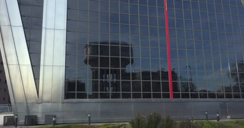 A large building with a large glass window and a red pole Stock Footage 327320004