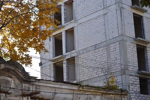 A large building with a lot of empty space and a tree in the background. Stock Photos