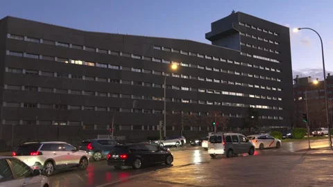 A large building with a lot of windows and a lot of cars parked in front of it Video stock 328516471