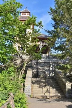 A large building with a steeple and a clock tower in central park Stock Photos