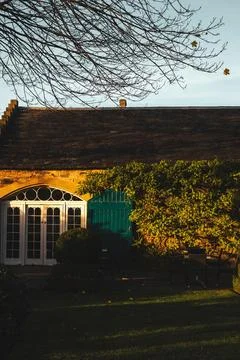 Large building with windows, each adorned with green shutters. Fotos de archivo