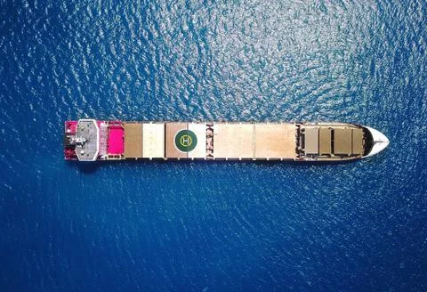 Large bulk carrier ship sailing in open ocean - aerial 4k view Stock Photos