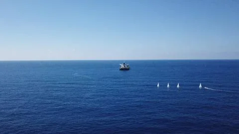 Large bulk carrier ship sailing in open ocean - aerial 4k view Stock Photos