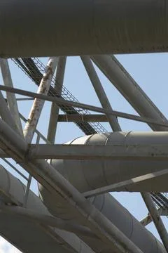 A large bunch of pipes is hanging down from a metal structure above Fotos Stock