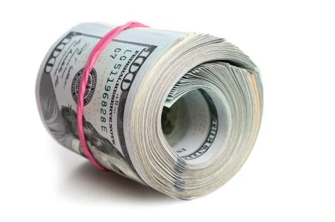 A large bundle of American dollars is stretched with an elastic band. On a wh Stock Photos