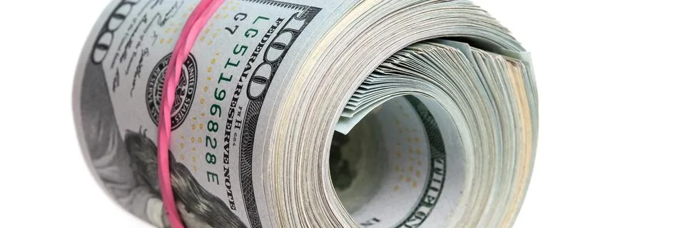 A large bundle of American dollars is stretched with an elastic band. Stock Photos