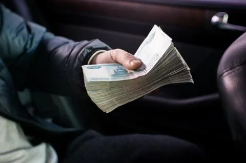 A large bundle of Russian money is squeezed in his hand. Stock Photos