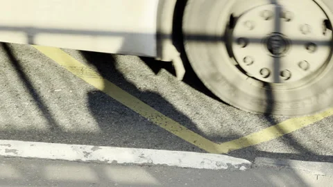 Large bus wheel rolls across a marked city bus stop lane Stock Footage 336937320